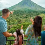 Family pointing at Arenal Volcano during a Find My Costa Rica nature experience.