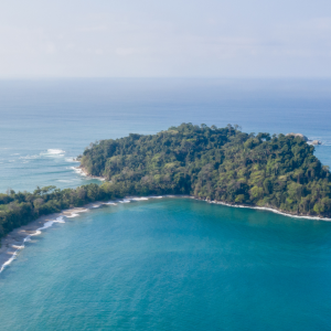 Aerial view of Manuel Antonio National Park, Costa Rica, showing lush jungle coastline and turquoise Pacific waters.