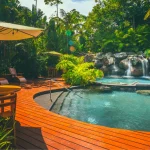 Tropical hot springs resort in Costa Rica with natural pool and waterfall surrounded by jungle.