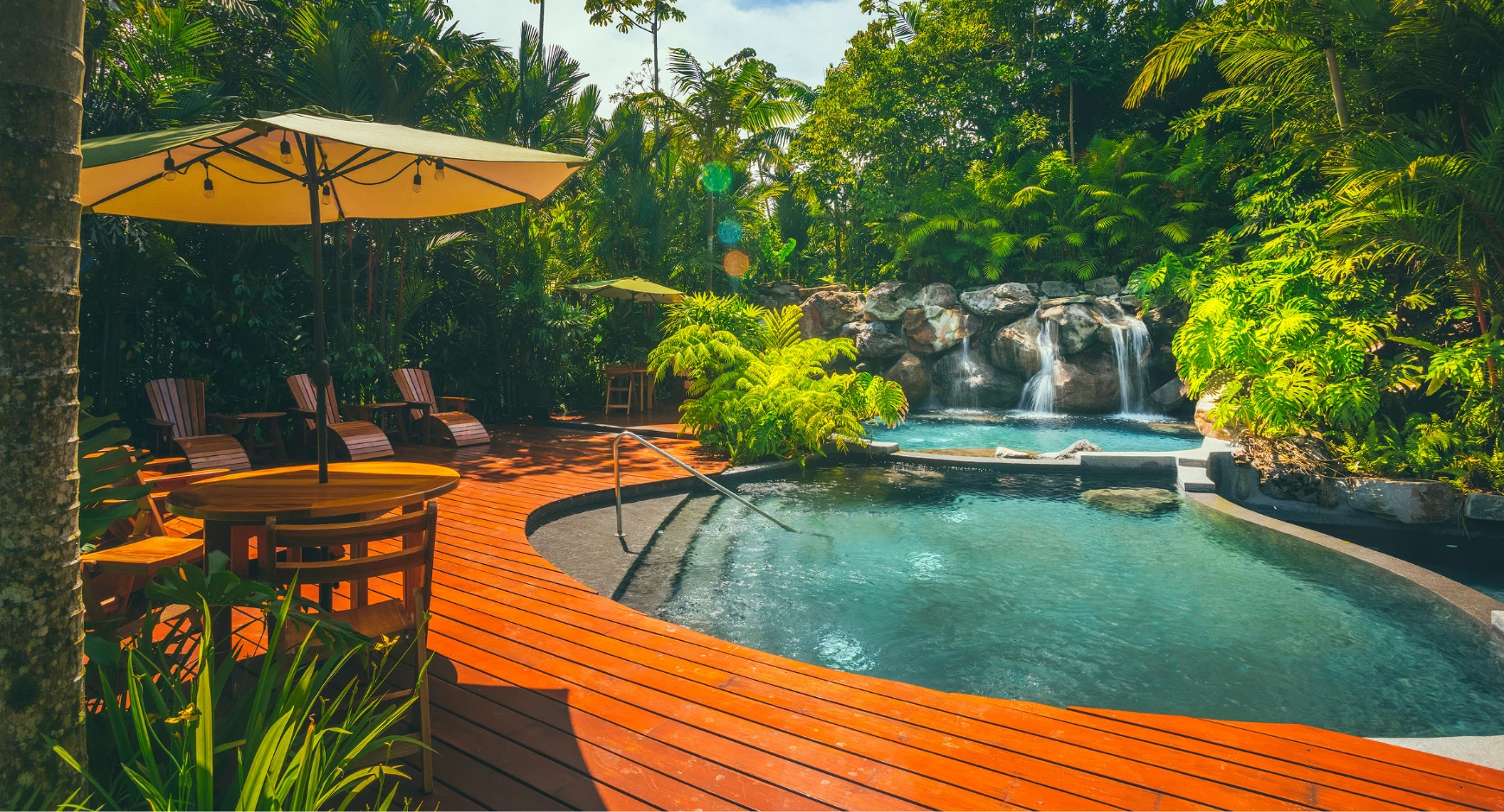Tropical hot springs resort in Costa Rica with natural pool and waterfall surrounded by jungle.