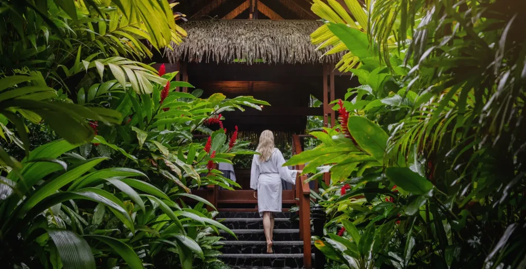 Traveler walking through lush tropical gardens at an eco-lodge in Costa Rica.