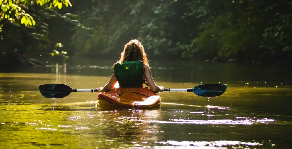 Traveler kayaking on a calm river surrounded by rainforest in Costa Rica.
