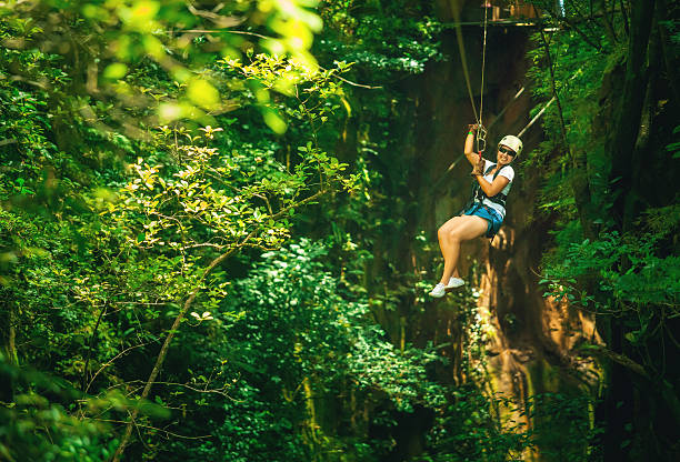 woman in her 40s doing a Canopy Tour Costa Rica, zip lines between trees. rafting-costa-rica