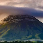 Arenal Volcano at sunset with mist and glowing sky, captured for Find My Costa Rica.