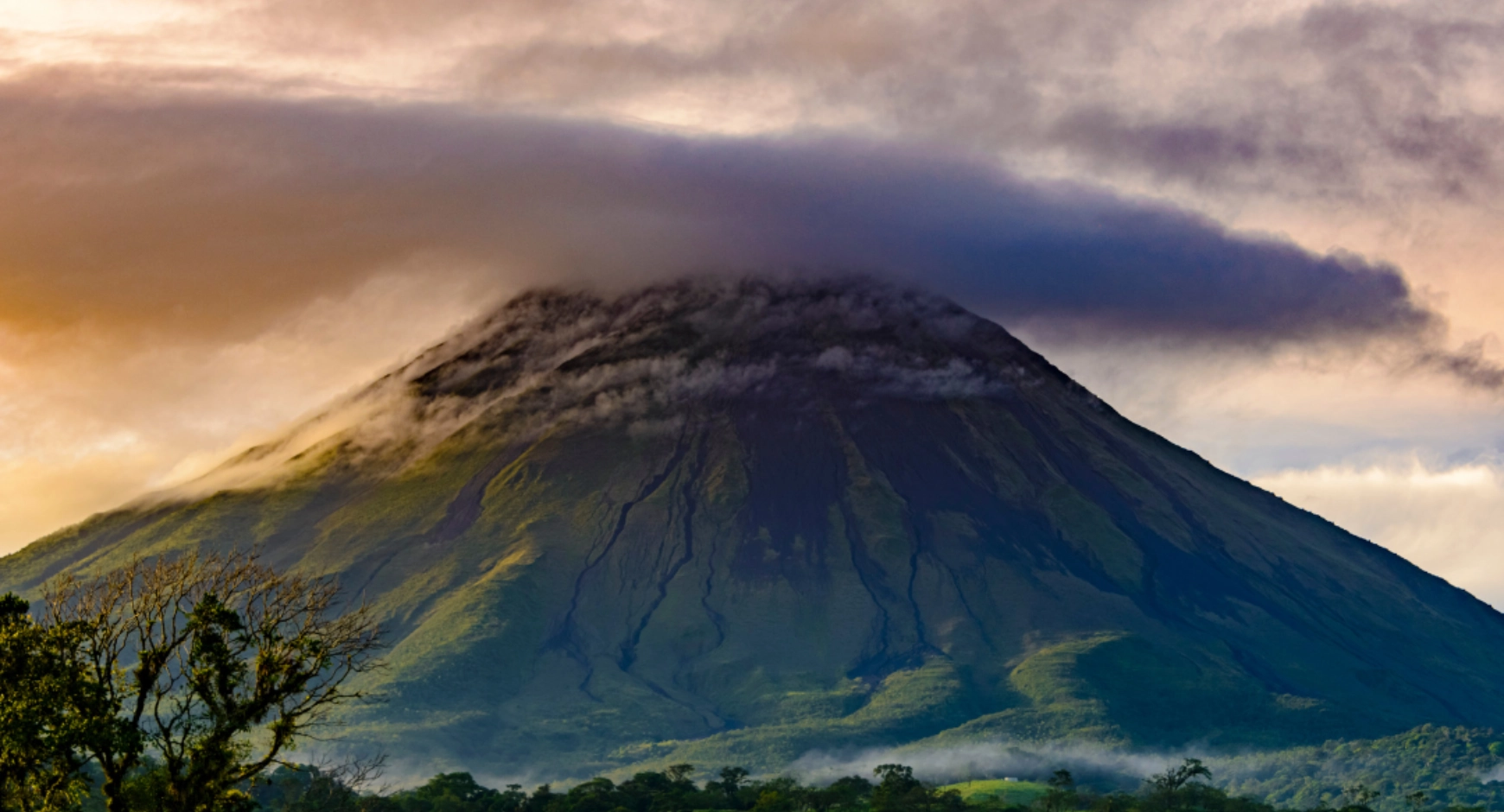 Arenal Volcano at sunset with mist and glowing sky, captured for Find My Costa Rica.