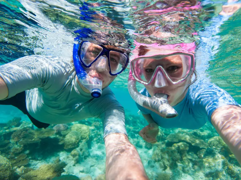 snorkeling-couple-tamarindo-costa-rica-reef.png couple snorkeling over coral reef in clear waters near tamarindo costa rica