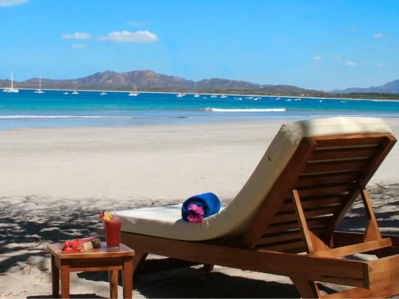 tamarindo-beachfront-lounger-costa-rica.png beachfront lounge chair with ocean view and drink on tamarindo beach costa rica