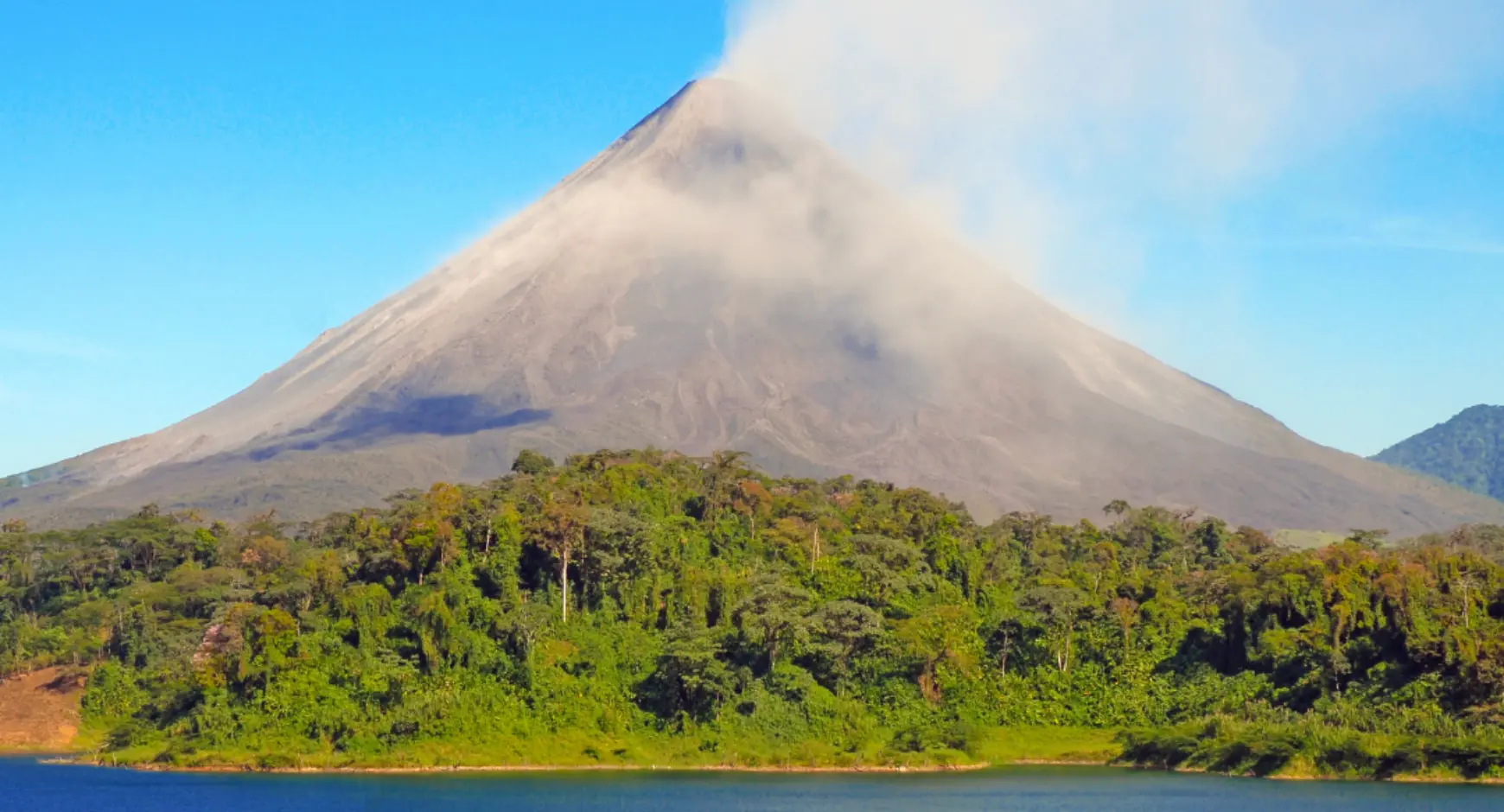 Tour guide showing volcanic rock to travelers during a hike near Arenal Volcano, Costa Rica.