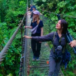 Travelers walking on hanging bridges through the lush rainforest canopy in Costa Rica.