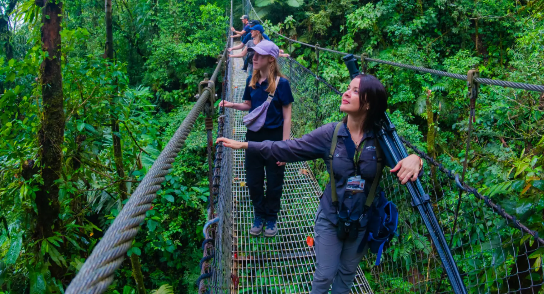 Travelers walking on hanging bridges through the lush rainforest canopy in Costa Rica.