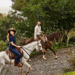Couple horseback riding through the lush hills of Pérez Zeledón, Costa Rica.