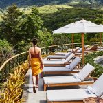 Woman walking by an infinity pool at a luxury wellness retreat in Pérez Zeledón, surrounded by green mountain views.