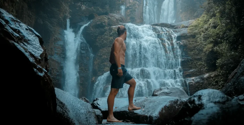 Traveler standing near a waterfall in a rocky canyon in Costa Rica